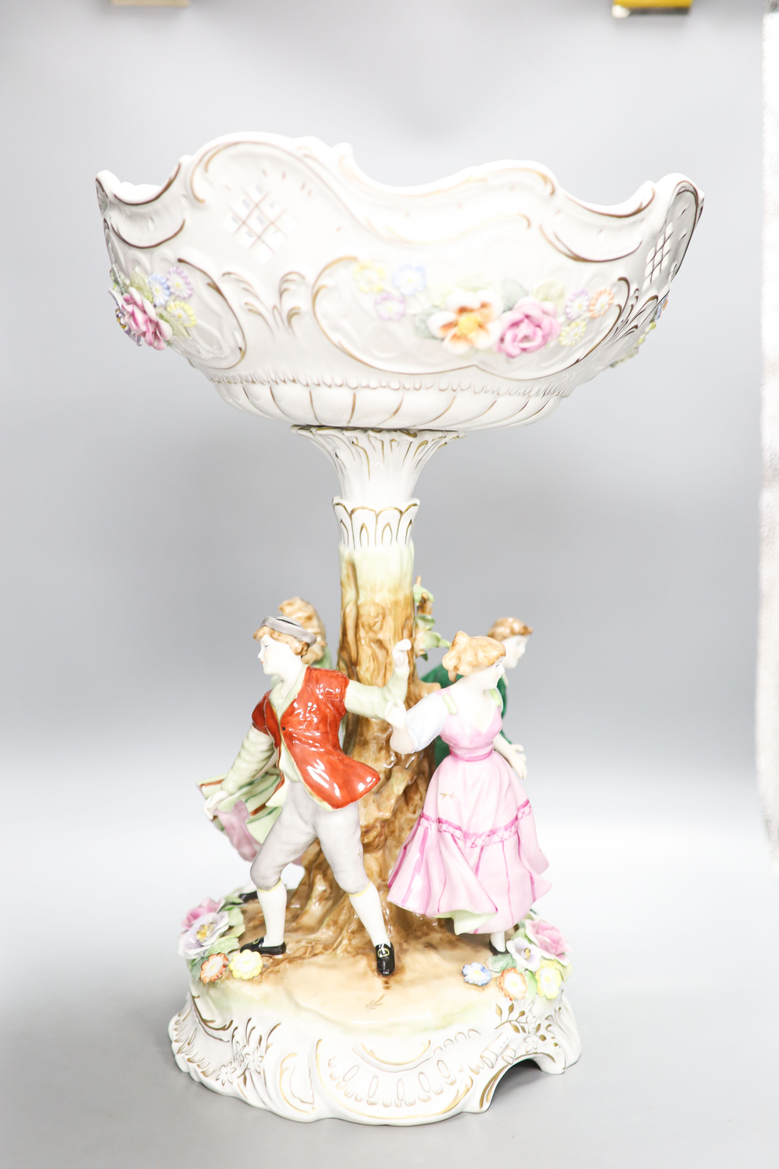 A German porcelain fruit stand, the stem decorated with four dancing figures 51cm